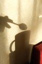 Blurred view shadow on beige wall with neutral pattern from cup with spoon and hand, authentic home concept