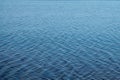 Blurred water background. Texture of small ripples on the water. Saturated blue shades with a light gradient