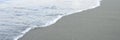 Blurred wave of the sea on the evening sand beach. banner.