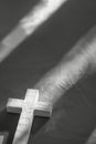 a white cross, with shadow, on a grey background