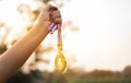 Blurred of woman hands raised and holding gold medals with Thai ribbon against blue sky background to show success in sport or Royalty Free Stock Photo