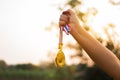 Blurred of woman hands raised and holding gold medals with Thai ribbon against blue sky background to show success in sport or Royalty Free Stock Photo