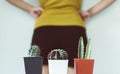 Blurred woman standing on white background with cactus and suffering from hemorrhoids