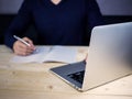 Blurred of working table desk with man writing notes, study and work from home concept