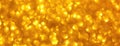 Blurred yellow sparkling background from sequins, macro. Shiny golden glittery bokeh of christmas garland