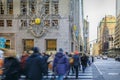 Blurred yellow taxi cabs speed past people and traffic cop at a busy crossing on 5th Avenue in Manhattan, New York, USA