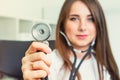 Blurred Young smiling female doctor holding her stethoscope to insinuate that it`s time for a check up in clinic on white backgro Royalty Free Stock Photo