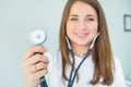 Blurred Young smiling female doctor holding her stethoscope to insinuate that it`s time for a check up in clinic on white backgro Royalty Free Stock Photo