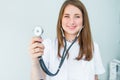 Blurred Young smiling female doctor holding her stethoscope to insinuate that it`s time for a check up in clinic on white backgro Royalty Free Stock Photo