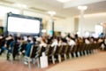 Blurry of auditorium for shareholders` meeting or seminar event with projector and white screen Royalty Free Stock Photo