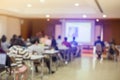 Blurry of auditorium for shareholders` meeting or seminar event with projector and white screen, many business people listening o Royalty Free Stock Photo