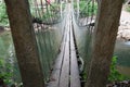 Blurry background of A wooden bridge fasteners with wire rope sling used crosses the stream