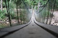Blurry background of A wooden bridge fasteners with wire rope sling used crosses the stream
