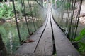 Blurry background of A wooden bridge fasteners with wire rope sling used crosses the stream