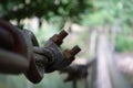 Blurry background of A wooden bridge fasteners with wire rope sling used crosses the stream