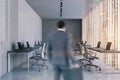 Man entering panoramic white open space office