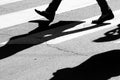 Black and white silhouette and shadow of a person crossing the s Royalty Free Stock Photo