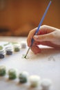 Blurry cropped photo of female hand painting with brush on paper Royalty Free Stock Photo