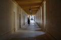 A woman in a long coat and high heels walks along a dark corridor to the exit Royalty Free Stock Photo