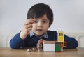 Blurry face of preschool kid showing 10 pence with smiling face, Selective focus kid boy  making stack money coins and counting Royalty Free Stock Photo
