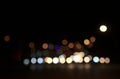 Blurry floating bokeh combination of cars on the road and street lights at the intersection, outdoor in modern big city.