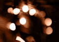 Blurry garland lights on a dark background. Festive Christmas and New Year background. Soft focus. Image toned in color