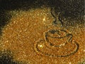 Blurry golden cup of coffee of glitter sparkle on black background