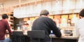 Blurry image background of people sitting and working in coffee shop keeping their social distancing.