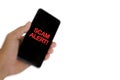 Blurry image of hand holding mobile phone with word SCAM ALERT