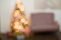 Blurry interior with a Christmas tree. Christmas and New Year`s bright interior in focus. Lots of glowing lights . Bokeh Royalty Free Stock Photo