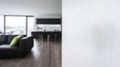 Blurry interior view of a modern living space with a dark sofa and a white wall on the right side Royalty Free Stock Photo