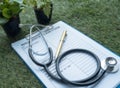 The blurry light design background of the stethoscope and insurance claim form put on green grass ground floor Royalty Free Stock Photo