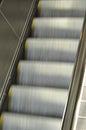 Blurry moving metallic escalator in a shopping mall, airport, metro, train station or other building. Perspective, going up or Royalty Free Stock Photo