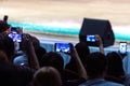 New Year performance of artists on stage. Many spectators in the hall photograph the concert program on their phones. Blurry.