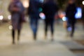 Blurry people silhouettes on night street in bokeh city lights Royalty Free Stock Photo