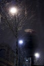 Blurry person walking alone in snowy city night Royalty Free Stock Photo