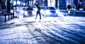 Blurry person walking alone in snowy city night Royalty Free Stock Photo