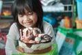 Blurry photo of a chubby Asian little girl celebrating her birthday at home. Happy and jovial in front of the cake. Soft focus Royalty Free Stock Photo