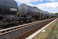 Blurry photo of railroad tank cars in motion, on a metal bridge over the river. Royalty Free Stock Photo