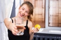 A blurry photo where a girl with a smile holds out a glass of clean water to the camera and holds a lemon in her hand. Benefits of Royalty Free Stock Photo