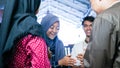 Blurry portrait of Muslim couples visiting their family or friend home while shaking hand and hugs on eid mubarak celebration