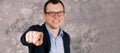 Blurry portrait of a young confident smiling modern businessman in glasses in a suit against the background of a gray Royalty Free Stock Photo