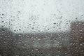blurry raindrops on glass, defocused building outside the window Royalty Free Stock Photo