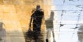 Blurry reflection shadow silhouettes of  a man and a boy walking on a wet street  on a sunny summer day Royalty Free Stock Photo