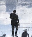 Blurry reflection shadow silhouettes of a man walking on a rainy Royalty Free Stock Photo