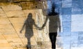 Blurry reflection shadow silhouettes of  a young couple walking on a rainy summer day Royalty Free Stock Photo