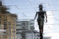 Blurry reflection silhouette of a person walking wet city stree