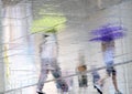 Blurry reflection silhouettes of two people walking on a rainy