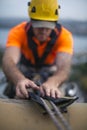 Blurry rope access worker abseiler wearing safety helmet fall protection placing safety ropes protection against sharp surfaces b