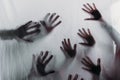 blurry scary silhouettes of human hands touching frosted glass Royalty Free Stock Photo